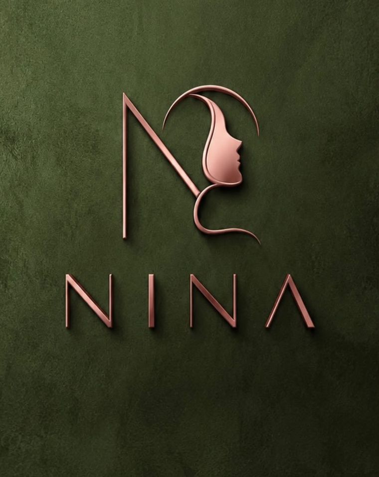 Logo da Clínica Nina em cobre na parede verde